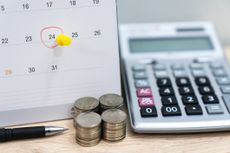 calendar sitting next to stacks of coins and calculator