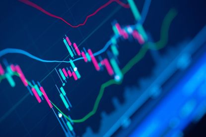 closeup of blue stock chart with red and green volume bars and a green moving average