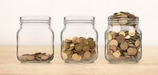 three glass jars with growing amounts of coins in them