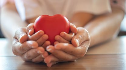 Adult and child holding heart symbolizing charity 