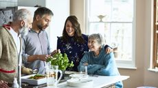 Young adults and their parents cook together.