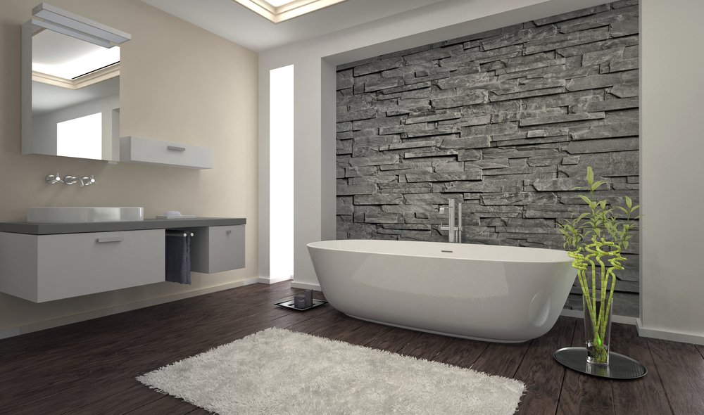 Modern bathroom with grey brick wall, freestanding bath and wall hung units