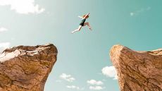 woman jumping between two rock formations